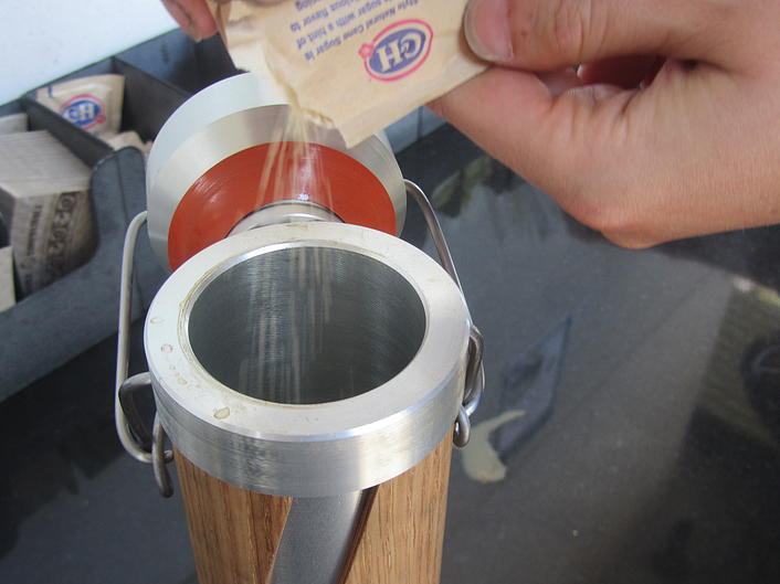 Close-up of a sugar packet being poured into the thermos